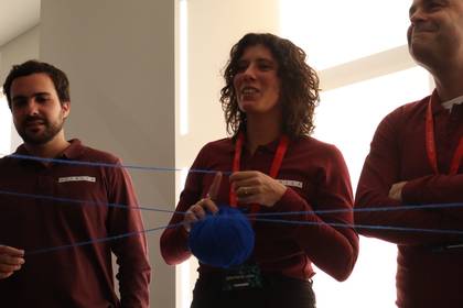 Profesionales de METRICA en una dinámica de equipo con un ovillo de lana