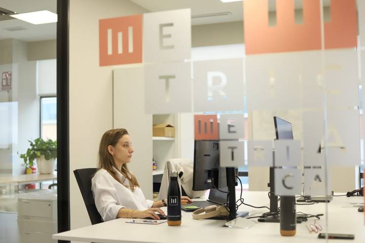 Profesional de METRICA trabajando en una oficina acristalada