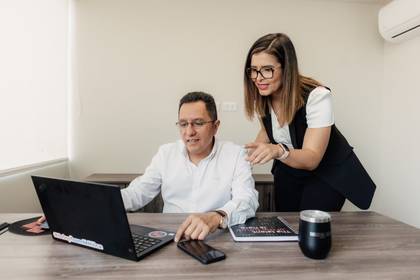 Dos profesionales de METRICA revisando juntos una laptop en la oficina
